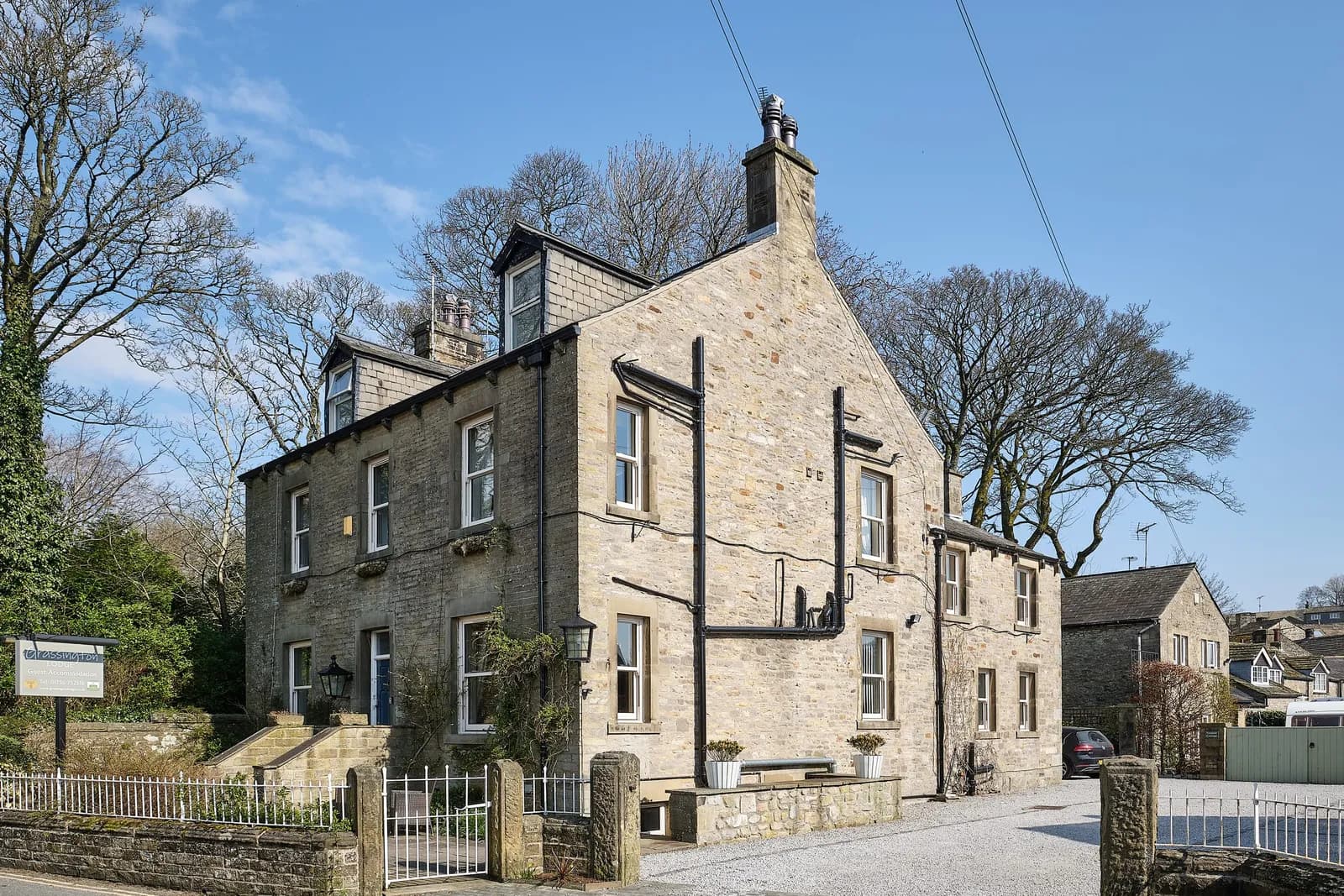 Grassington Lodge, a tall stone Dales house with a slate roof under a blue sky