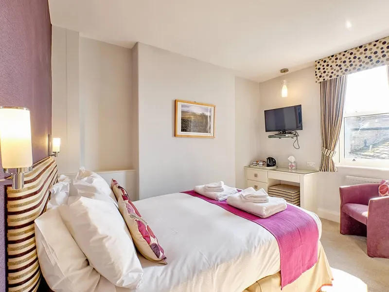 Room Two at Grassington Lodge with pink bedding and a window seat