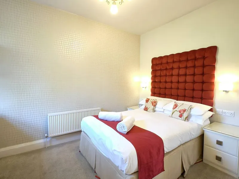 Room Five at Grassington Lodge with a red buttoned headboard