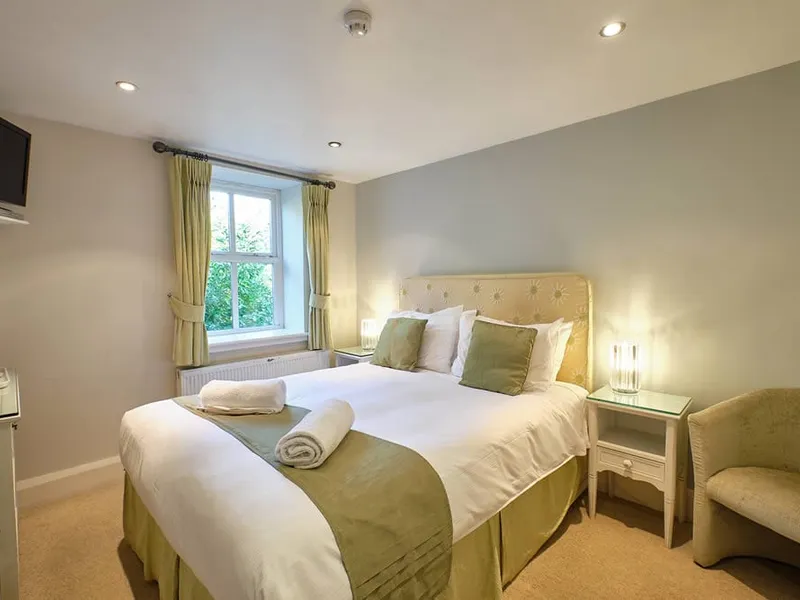 Room Six at Grassington Lodge with a sage headboard