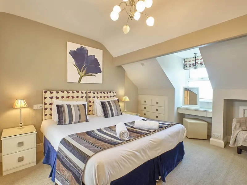 Room Seven under the eaves with a blue floral print above the bed