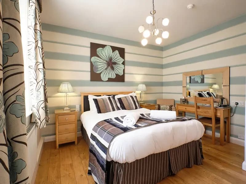 Room Nine, a ground-floor double with oak flooring and striped wallpaper
