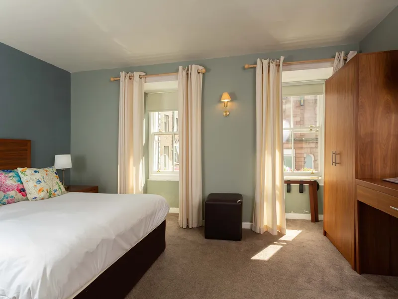 The superior double room at the Queens Head, with blue walls and two tall windows