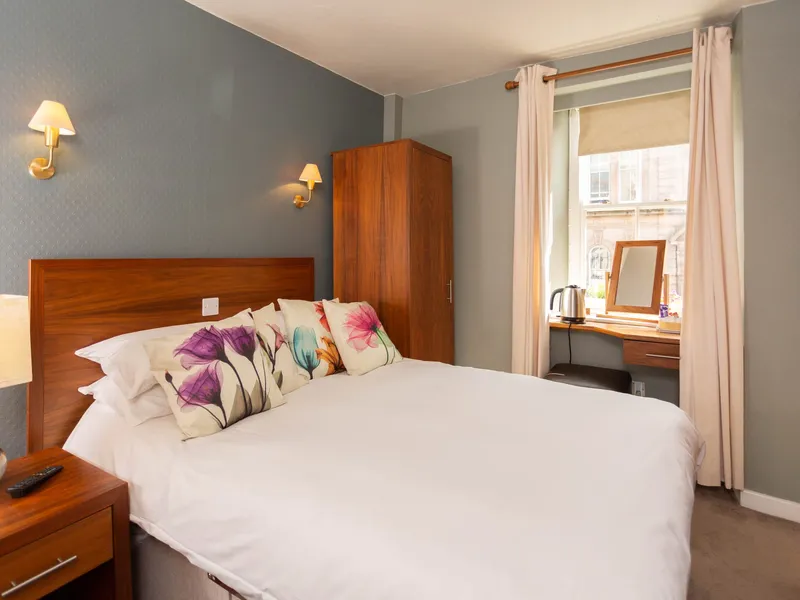 The double room at the Queens Head, with tulip cushions and a window onto the town