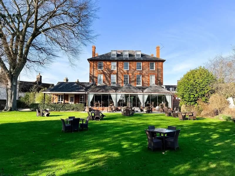 The Riverside House Hotel, a red-brick Georgian house seen across its lawn on a sunny day