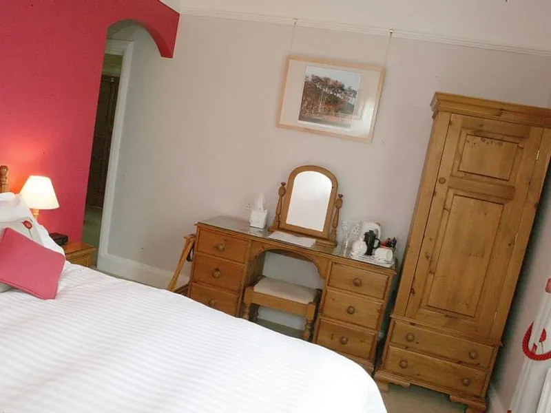 Room Four at Grassington Lodge with pine furniture and a red wall