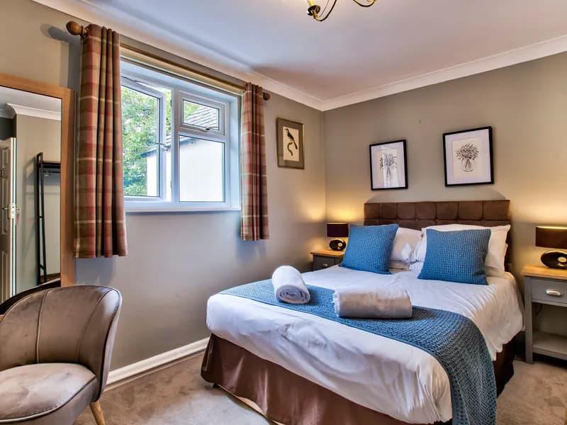 A twin room at The Vines with an armchair by the window